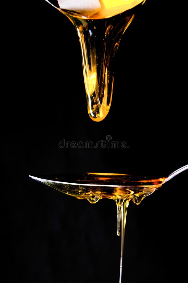 Honey onto a spoon stock photo. Image of alcohol, lighting 262112424