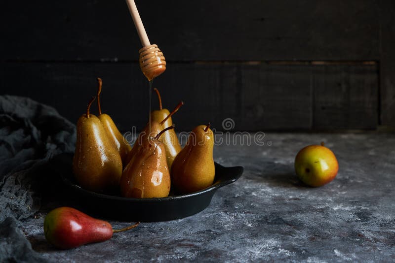 Honey poured baked pears in a plate Dark photo stock photo Honey poured baked pears in a plate Dark photo stock photo