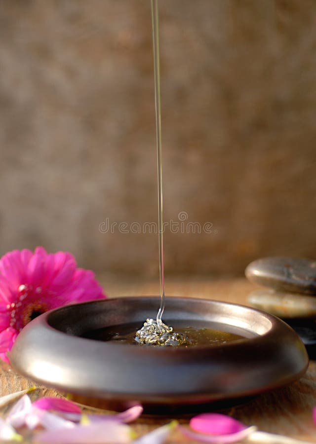 Honey dripping, flowers and spa rocks around. Honey dripping, flowers and spa rocks around