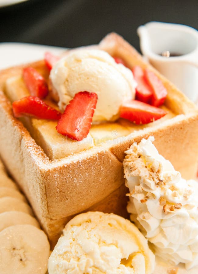 Honey toast with strawberry and vanilla ice cream. Desert with fruit.