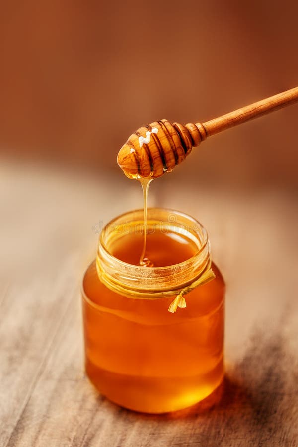Honey with Wooden Honey Dipper on Wooden Table. Copyspace Stock Photo