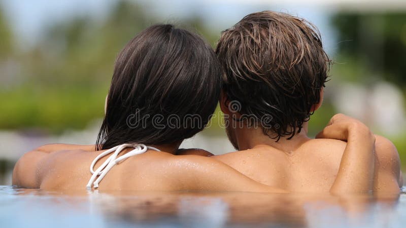 Honeymoon-paret relaxar ihop - simbassäng arkivfilmer