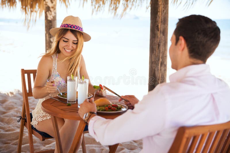 Honeymooners pranzando alla spiaggia immagini stock Honeymooners pranzando alla spiaggia immagini stock