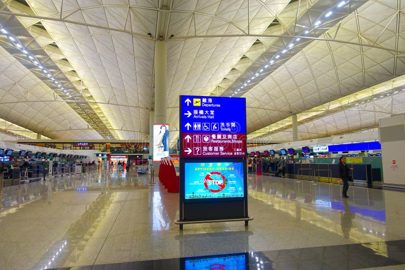 HONG KONG, CHINA - JANUARY 26, 2017: Unidentified people walking near of informative sign inside of the airport of Hong