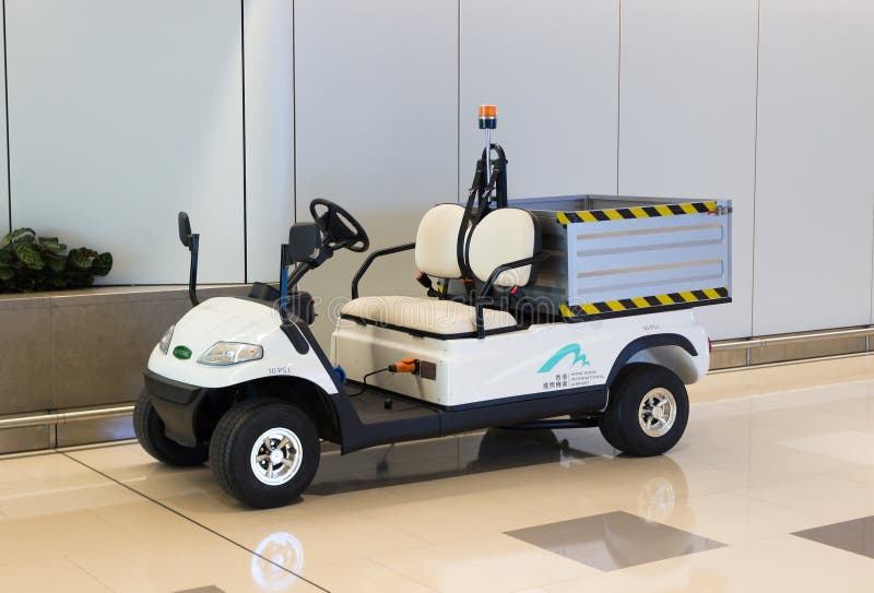 Hong Kong, China - September 22, 2018: De witte kar van het elektrisch nutsgolf of auto met fouten voor vervoer van bagage en lad stock fotografie Hong Kong, China - September 22, 2018: De witte kar van het elektrisch nutsgolf of auto met fouten voor vervoer van bagage en lad stock fotografie