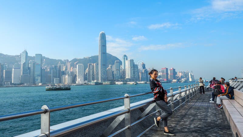 HONG KONG - DECEMBER 10,2016: De toeristen nemen beelden en genieten van de beroemde Hong Kong-eilandhorizon over Victoria Harbou stock foto HONG KONG - DECEMBER 10,2016: De toeristen nemen beelden en genieten van de beroemde Hong Kong-eilandhorizon over Victoria Harbou stock foto