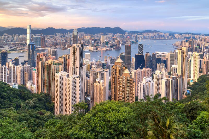 Hong Kong SAR Kina - circa Juli 2015: Horisont av Hong Kong från Victoria Peak på solnedgången arkivbild Hong Kong SAR Kina - circa Juli 2015: Horisont av Hong Kong från Victoria Peak på solnedgången arkivbild