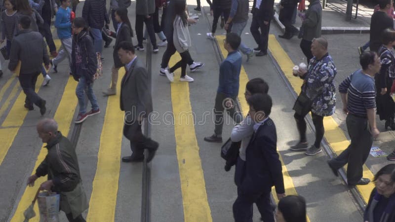 Hong Kong stad, Kina - Juni, 2019: folkövergångsställe väg på stadsgatan Upptaget folk som flyttar sig över