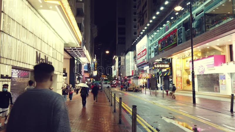 Hongkong, China- 2020: Straßen Nacht Schaufenster, auf dem Bürgersteig Leuteweg