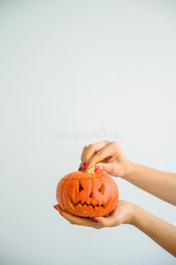 Honhänder som håller en pumpa för Halloween När en kvinna närmar sig öppnar den bakre delen på en vit bakgrund. royaltyfria bilder Honhänder som håller en pumpa för Halloween När en kvinna närmar sig öppnar den bakre delen på en vit bakgrund. royaltyfria bilder