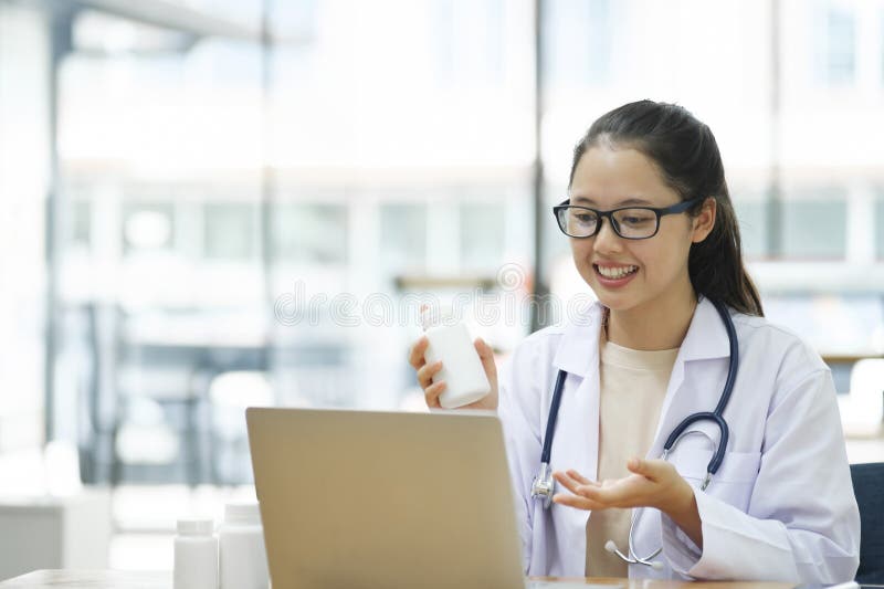 Honläkare som konsulterar patienten online från kliniskt kontor. arkivfoto