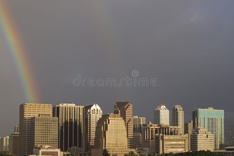 A rainbow`s end lands squarely in downtown Honolulu, island of O`ahu, Hawai`i. A rainbow`s end lands squarely in downtown Honolulu, island of O`ahu, Hawai`i