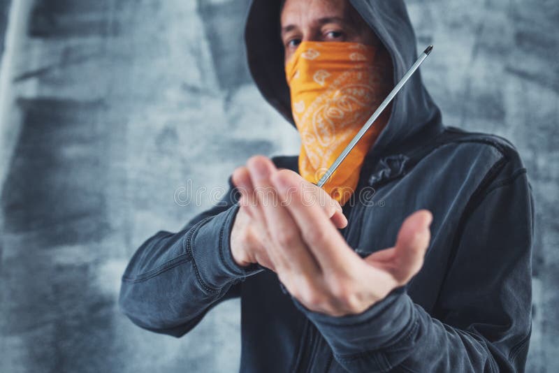 Hooded gang member criminal with screwdriver royalty free stock photography Hooded gang member criminal with screwdriver royalty free stock photography