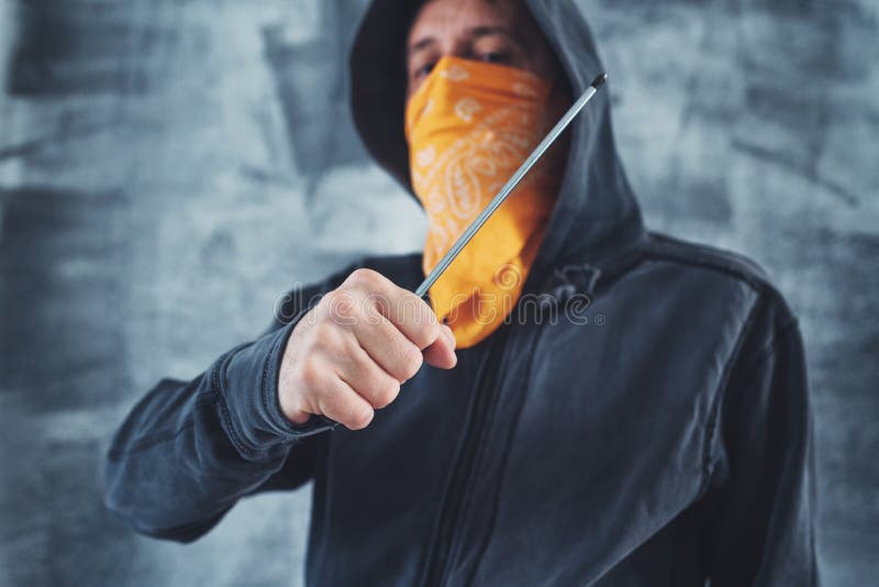 Hooded gang member criminal with screwdriver stock photo Hooded gang member criminal with screwdriver stock photo