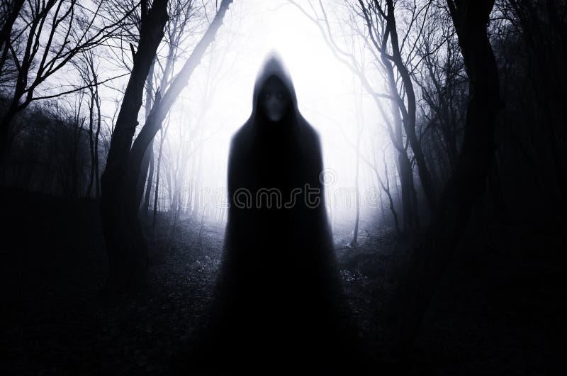 Hooded ghost monster in haunted forest with fog on Halloween. Haunted dark spooky scary mysterious Transylvanian forest with fog and ghost. Hooded ghost monster in haunted forest with fog on Halloween. Haunted dark spooky scary mysterious Transylvanian forest with fog and ghost