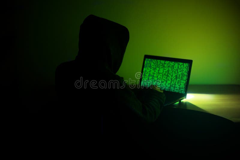 Hooded Hacker is using his Computer for Hacking Server stock image Hooded Hacker is using his Computer for Hacking Server stock image