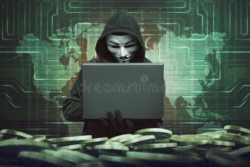 Hooded man with anonymous mask using laptop to hacking bank