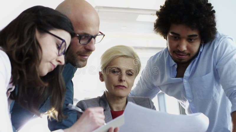 Hooggeplaatste vrouw die samenwerkt met haar multi - etnische team in functie