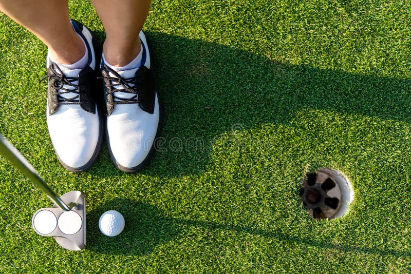 Hoogste Aziatische sportieve de vrouwennadruk die van de Weergevengolfspeler golfbal op het groene golf zetten stock foto Hoogste Aziatische sportieve de vrouwennadruk die van de Weergevengolfspeler golfbal op het groene golf zetten stock foto