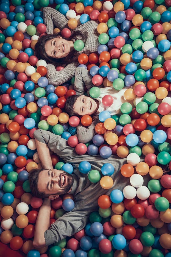 Hoogste mening Gelukkige familie die in pool met ballen liggen stock fotografie Hoogste mening Gelukkige familie die in pool met ballen liggen stock fotografie