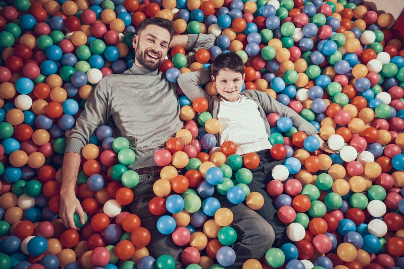 Hoogste mening Gelukkige papa en zoon in pool met ballen stock fotografie Hoogste mening Gelukkige papa en zoon in pool met ballen stock fotografie