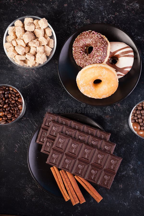 Hoogste mening van chocoladetabletten, donuts, bruine suiker met pinda's in chocolade en koffiebonen stock afbeeldingen Hoogste mening van chocoladetabletten, donuts, bruine suiker met pinda's in chocolade en koffiebonen stock afbeeldingen