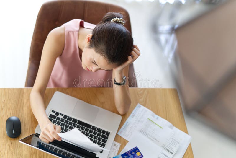 Hoogste mening van de beklemtoonde jonge zorg van de zittings Aziatische vrouw over haar krediet royalty-vrije stock foto's Hoogste mening van de beklemtoonde jonge zorg van de zittings Aziatische vrouw over haar krediet royalty-vrije stock foto's