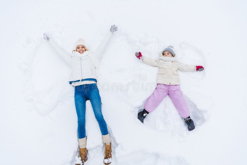 hoogste mening van gelukkige moeder en dochter die sneeuwengelen maken stock illustratie hoogste mening van gelukkige moeder en dochter die sneeuwengelen maken stock illustratie