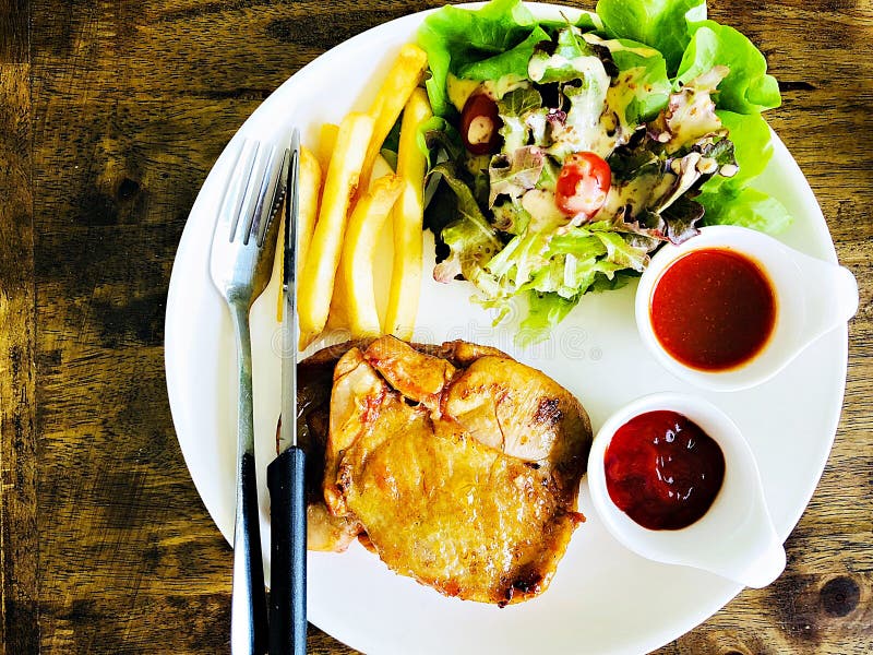 Hoogste mening van geroosterd kippenlapje vlees met salade en frieten op houten lijst stock foto Hoogste mening van geroosterd kippenlapje vlees met salade en frieten op houten lijst stock foto