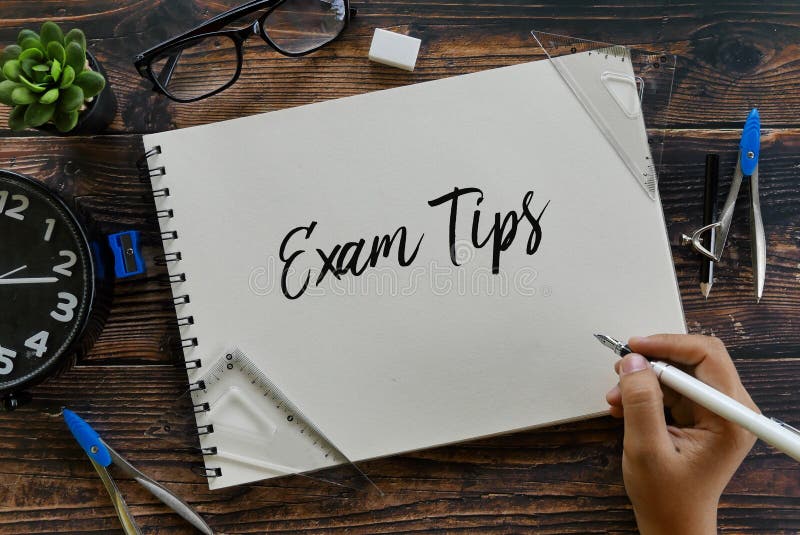 Hoogste mening van kantoorbehoeften, klok, glazen, installatie en van de handholding pen het schrijven Examenuiteinden op notitie royalty-vrije stock afbeeldingen Hoogste mening van kantoorbehoeften, klok, glazen, installatie en van de handholding pen het schrijven Examenuiteinden op notitie royalty-vrije stock afbeeldingen