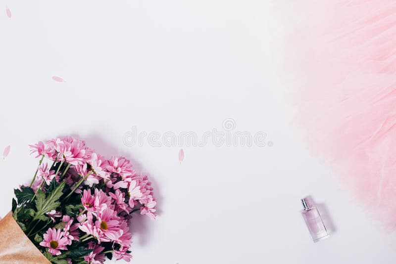 Top view of pink bouquet, petals, perfume and tulle on white background. Feminine frame with copy space. Flat lay template. Top view of pink bouquet, petals, perfume and tulle on white background. Feminine frame with copy space. Flat lay template.