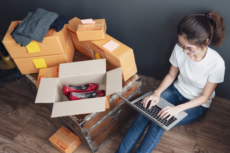 Hoogste mening van vrouwen die laptop computer van huis werken aan houten vloer met postpakket, die online ideeënconcept verkopen royalty-vrije stock afbeelding Hoogste mening van vrouwen die laptop computer van huis werken aan houten vloer met postpakket, die online ideeënconcept verkopen royalty-vrije stock afbeelding