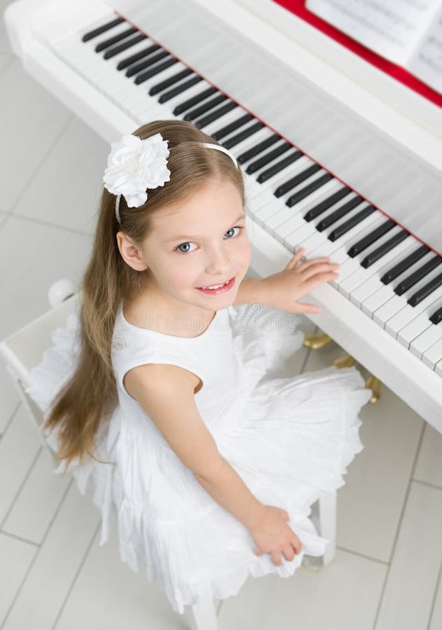 Hoogste mening van weinig musicus in witte kleding het spelen piano royalty-vrije stock foto Hoogste mening van weinig musicus in witte kleding het spelen piano royalty-vrije stock foto