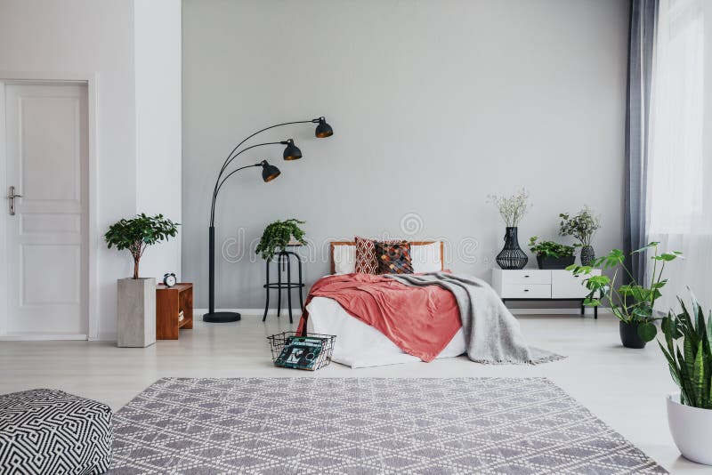 Hoogtepunt van in slaapkamer met het comfortabele bed van de koningsgrootte, witte houten bed zijlijst en planta royalty-vrije stock afbeeldingen Hoogtepunt van in slaapkamer met het comfortabele bed van de koningsgrootte, witte houten bed zijlijst en planta royalty-vrije stock afbeeldingen