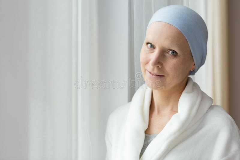 Breast cancer survivor after chemotherapy in a robe, looking positive and hopeful. Breast cancer survivor after chemotherapy in a robe, looking positive and hopeful
