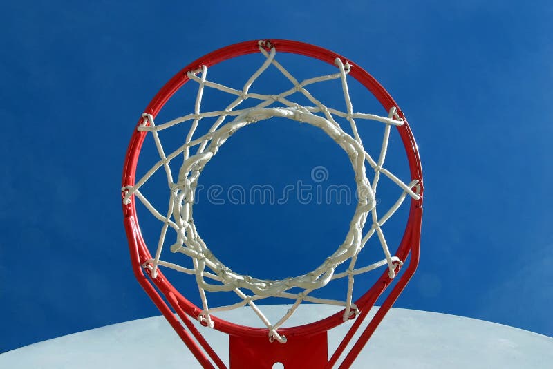 A basketball hoop, net and backboard on a playground, shot from below. A basketball hoop, net and backboard on a playground, shot from below.