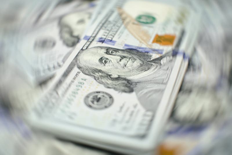 A stack of money. Heap of one hundred dollar bills on money background. Fake money. Shallow depth of field. Selective focus. A stack of money. Heap of one hundred dollar bills on money background. Fake money. Shallow depth of field. Selective focus.