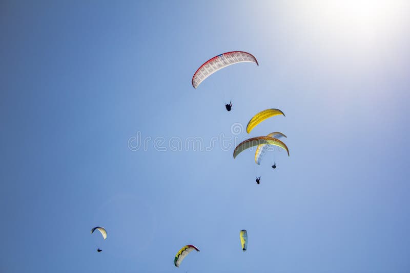 Hoppa fallskärm många paragliders på färgrikt i en klar blå himmel med ljust solsken royaltyfria foton Hoppa fallskärm många paragliders på färgrikt i en klar blå himmel med ljust solsken royaltyfria foton