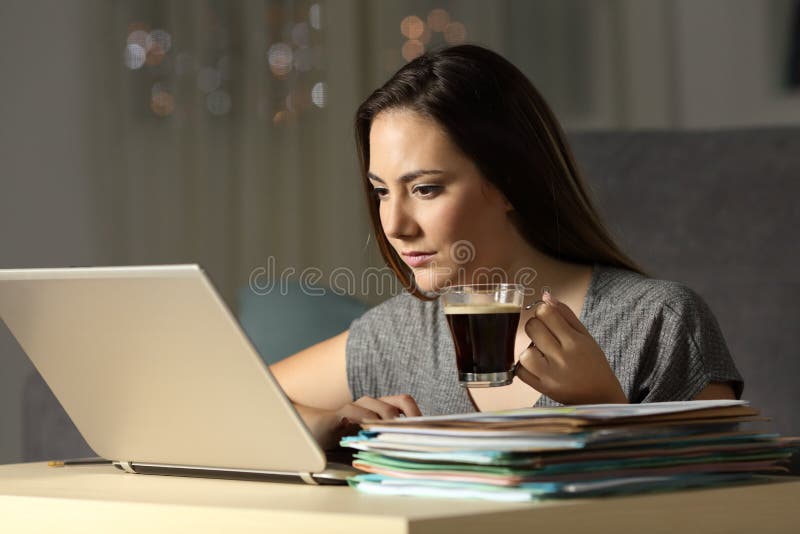 Horas atrasadas de trabalho independentes que guardam a caneca de café foto de stock Horas atrasadas de trabalho independentes que guardam a caneca de café foto de stock