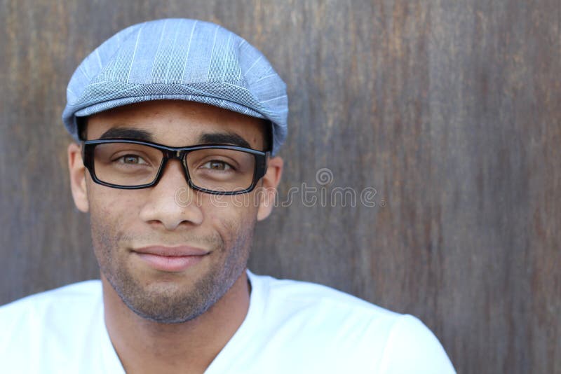 Horisontalstående av en stilig ung afrikansk man som smicing på texturerad brun väggbakgrund fotografering för bildbyråer Horisontalstående av en stilig ung afrikansk man som smicing på texturerad brun väggbakgrund fotografering för bildbyråer