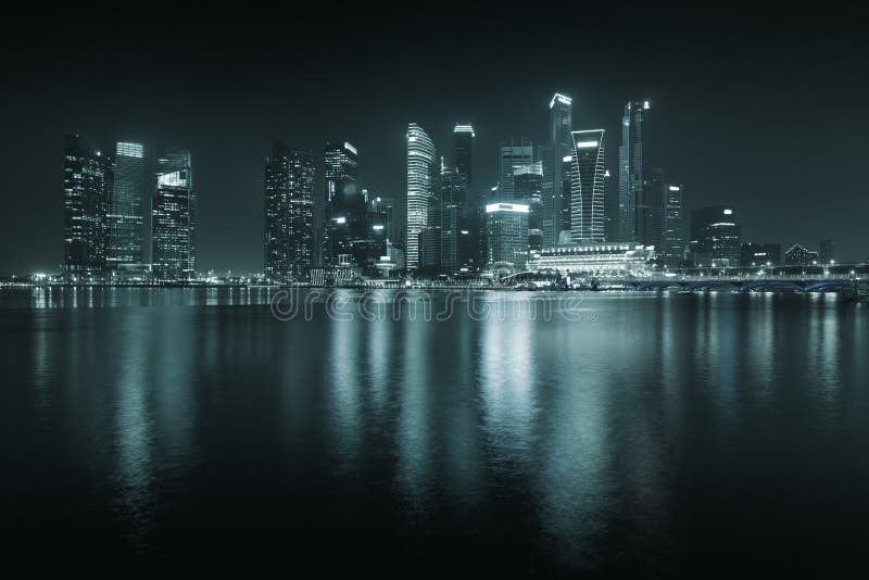 Horizon de Singapour la nuit - gratte-ciel avec des réflexions. photo stock Horizon de Singapour la nuit - gratte-ciel avec des réflexions. photo stock