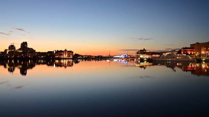 Horizon met de heldere avondlichten van de stralen van Victoria City en van de zonsondergang de lichten vormen een spiegelbeeld o stock foto Horizon met de heldere avondlichten van de stralen van Victoria City en van de zonsondergang de lichten vormen een spiegelbeeld o stock foto