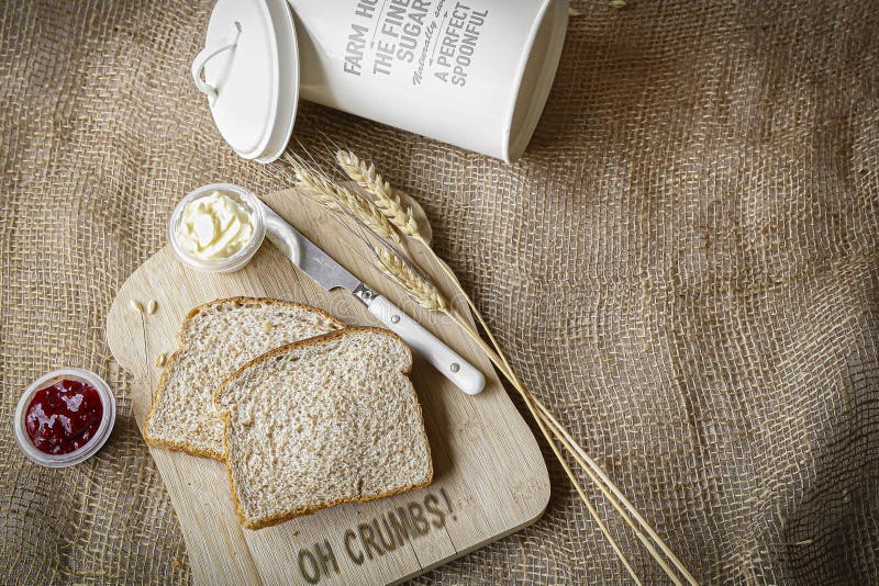 Two slices of whole wheat bread on wood cutting board