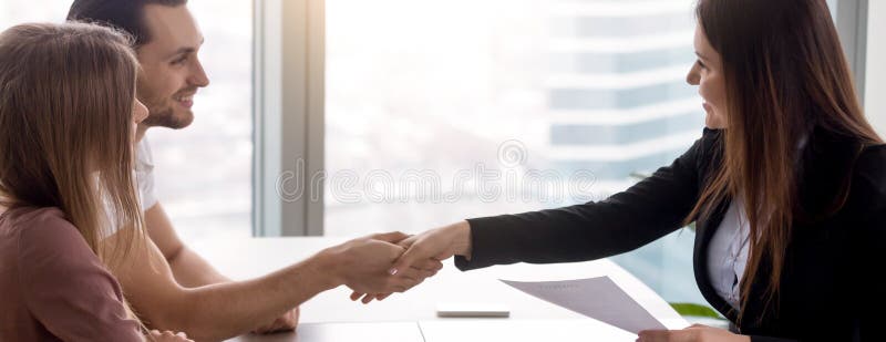 Horizontal image couple signing real estate contract handshaking with realtor stock photography Horizontal image couple signing real estate contract handshaking with realtor stock photography