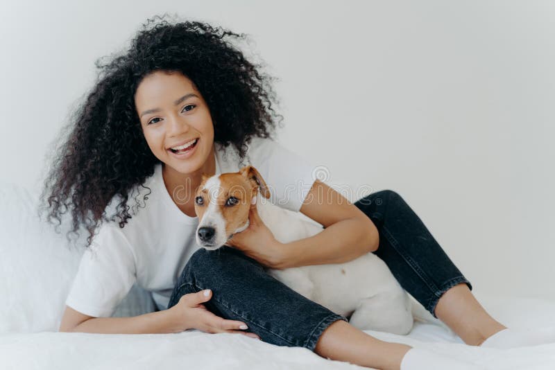 Horizontal Shot of Glad Afro Woman Rests in Bed with Dog, Have Playful  Mood, Pose Together in Bedroom Against White Background. Stock Photo -  Image of glad, animal: 163071508