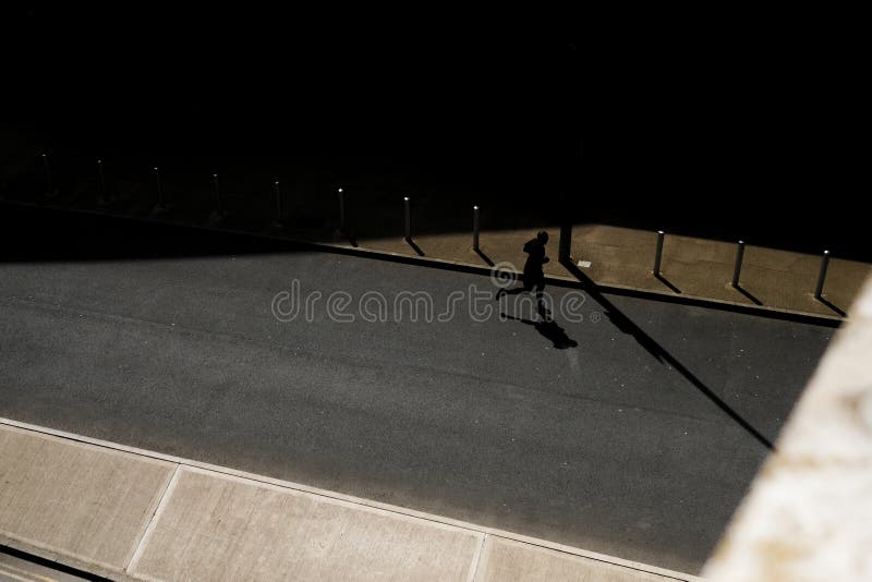Horizontal shot of a running person on the empty road at nighttime stock images