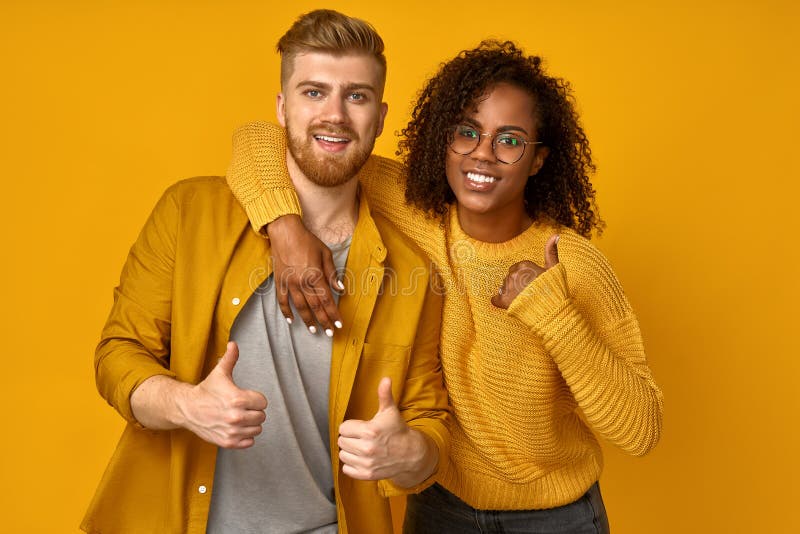 Horizontal shot of satisfying mixed race couple laughs happily, leans at the shoulder of boyfriend, come together on a royalty free stock photos Horizontal shot of satisfying mixed race couple laughs happily, leans at the shoulder of boyfriend, come together on a royalty free stock photos