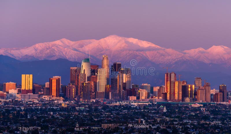 Downtown Los Angeles skyline with snow capped mountains behind at twilight. Downtown Los Angeles skyline with snow capped mountains behind at twilight