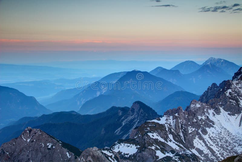 Horizonte cor-de-rosa de incandescência e cumes azuis, escala Áustria de Karawanken imagens de stock royalty free Horizonte cor-de-rosa de incandescência e cumes azuis, escala Áustria de Karawanken imagens de stock royalty free