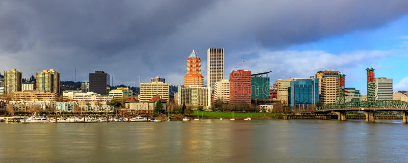 Portland, Oregon - Janurary 29, 2016: Portland downtown skyline showing Wells Fargo Center and KOIN Center, behind Willamette river and waterfront park. Portland, Oregon - Janurary 29, 2016: Portland downtown skyline showing Wells Fargo Center and KOIN Center, behind Willamette river and waterfront park.